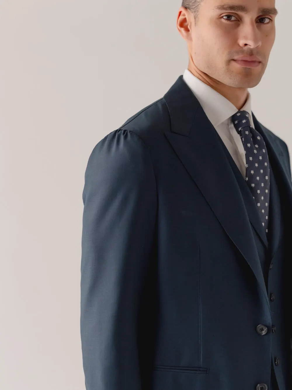 Navy three-piece suit with a spotted tie