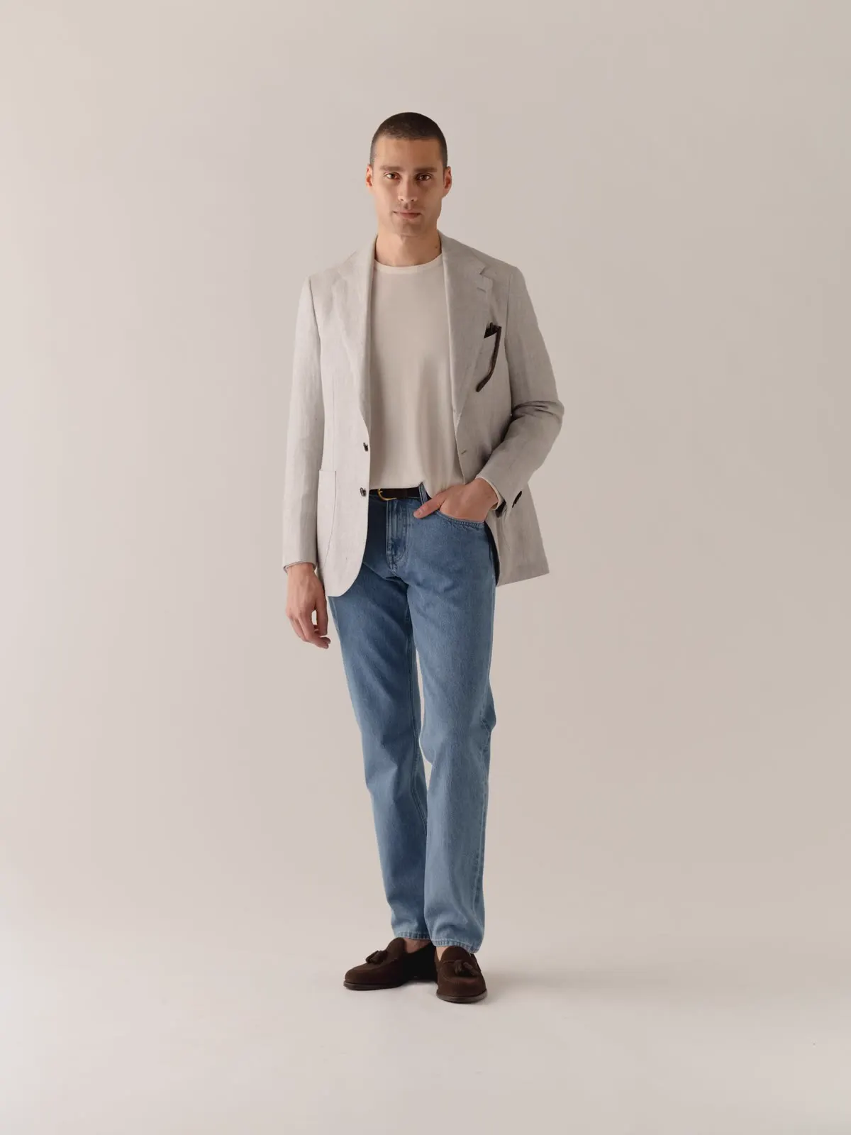 Mand i lys blazer over hvid T-shirt og jeans