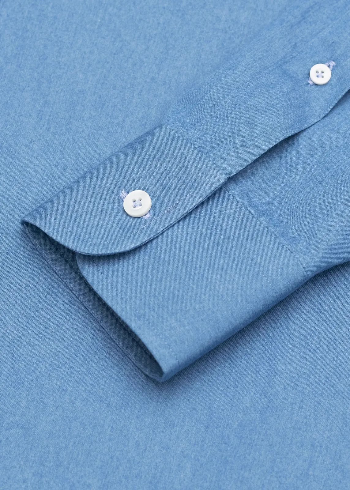 Nærbillede af manchetten på en blå denimskjorte