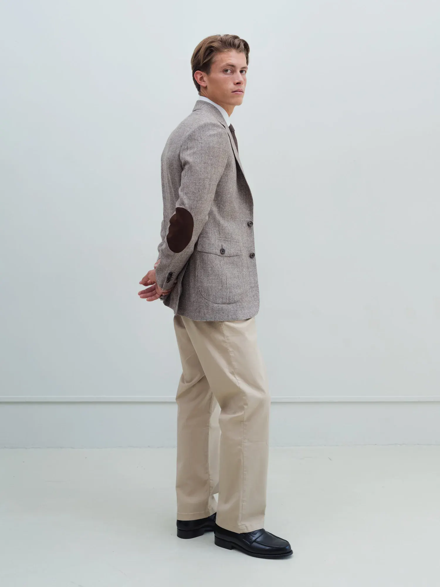 Mand i beige chinos og gråbrun blazer set fra siden