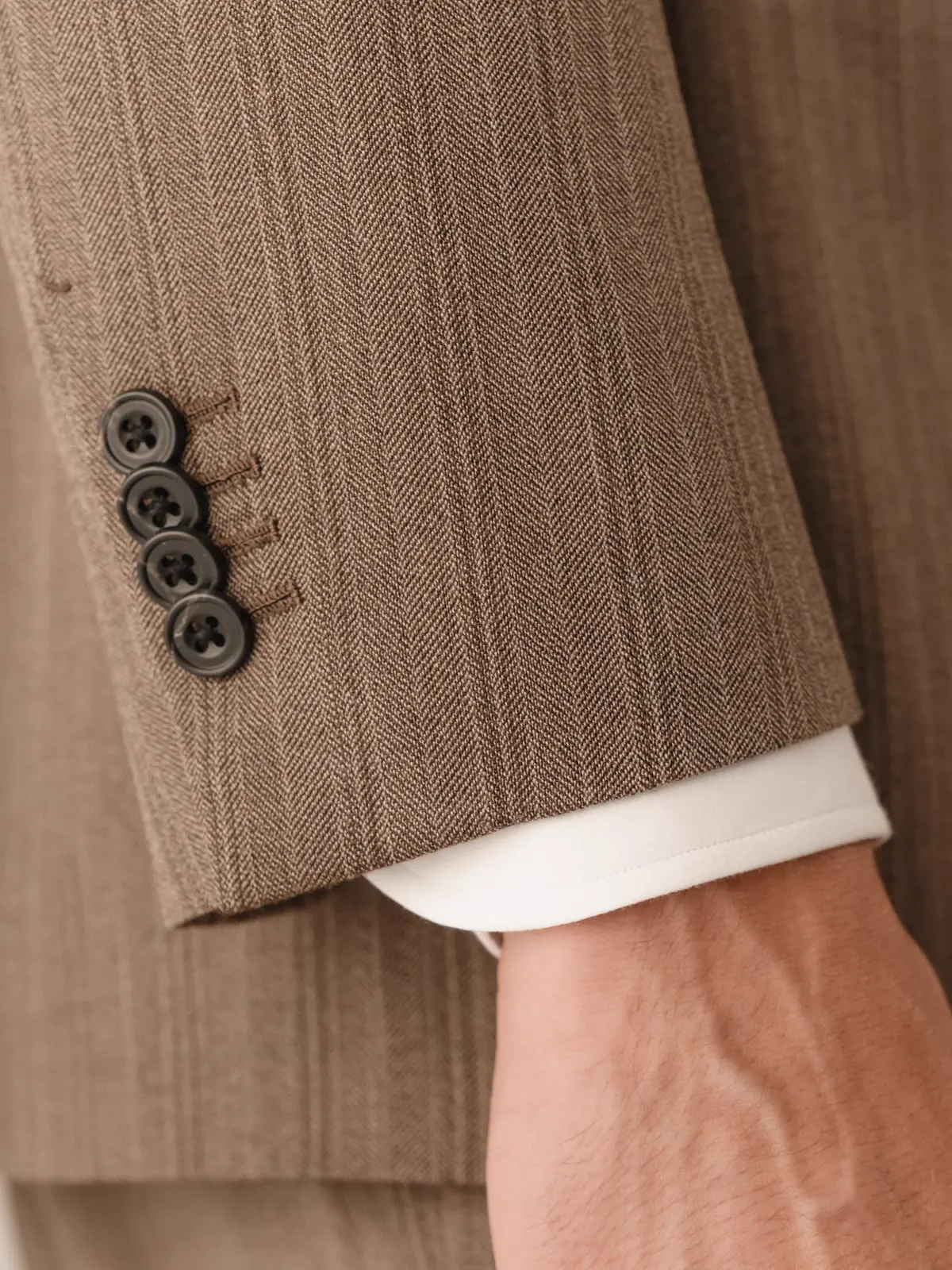 Close-up of the sleeve buttons on a brown striped jacket