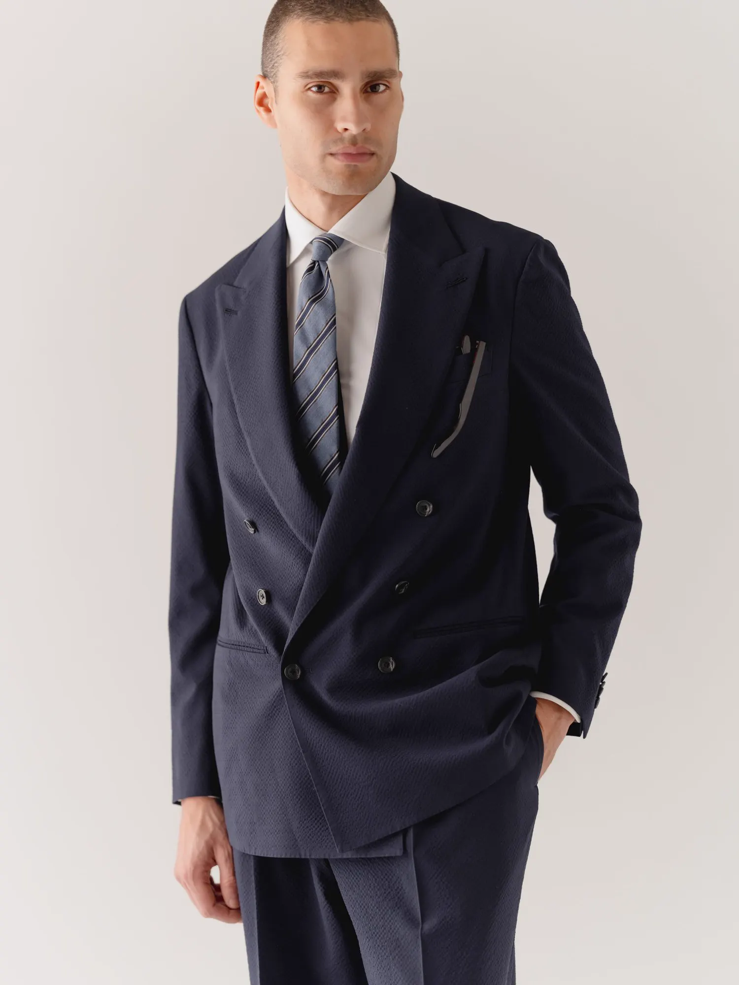Dark blue double-breasted suit with a striped tie