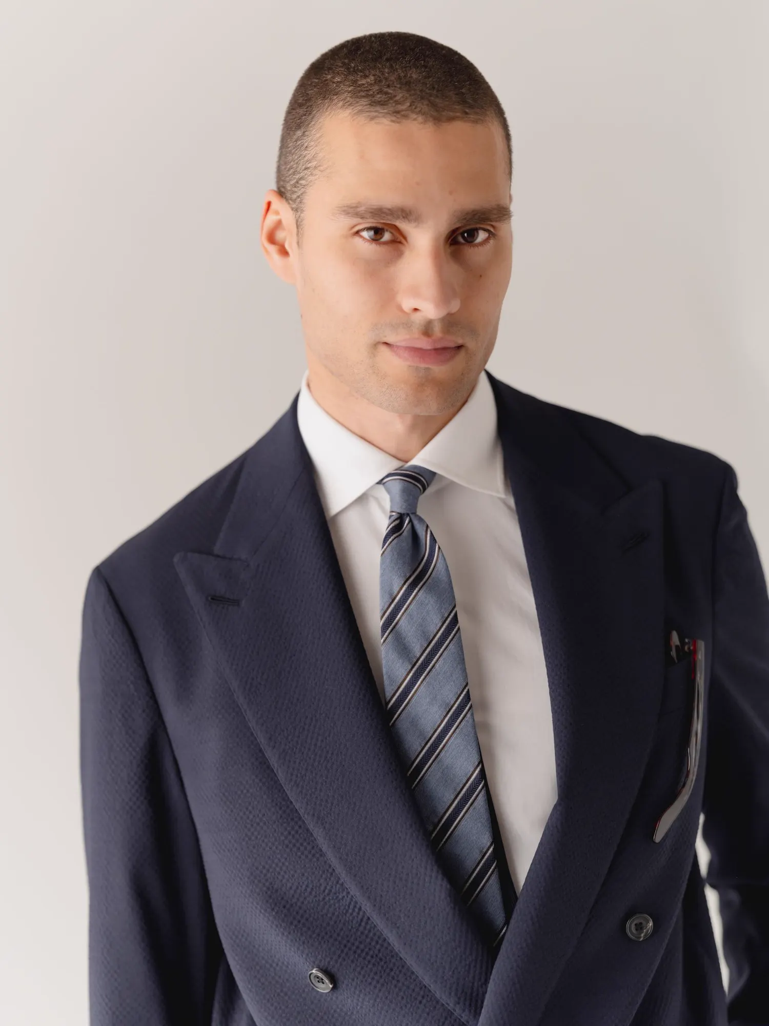 Portrait in a dark blue double-breasted suit with a striped tie