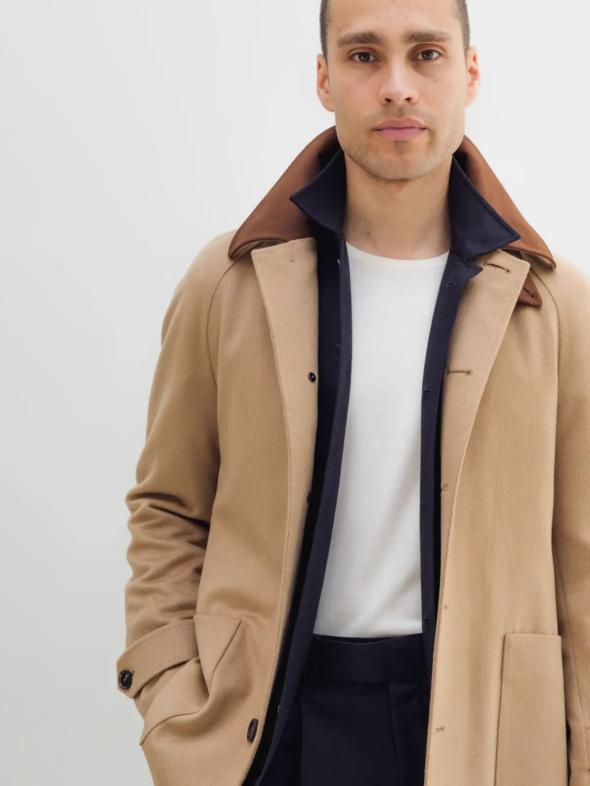 Mand i camel frakke med krave i ruskind over hvid T-shirt