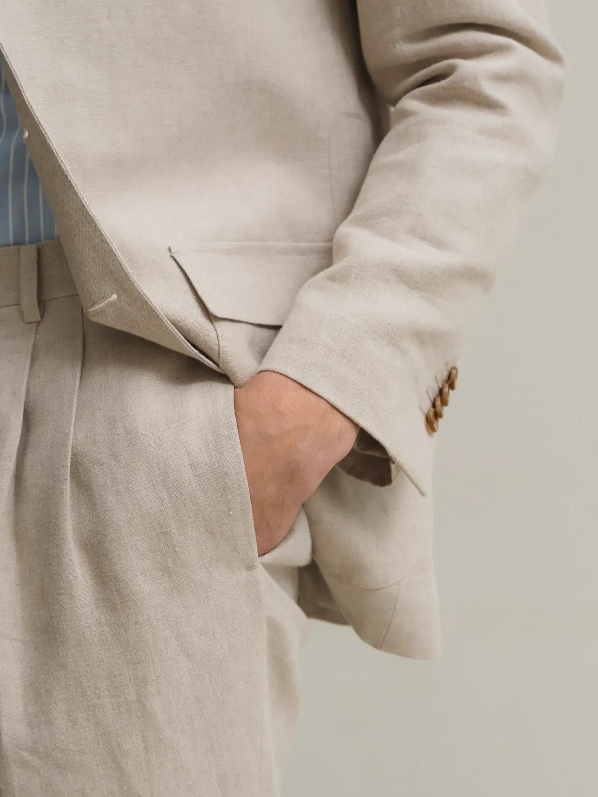 Close-up of a light linen suit with hand in pocket