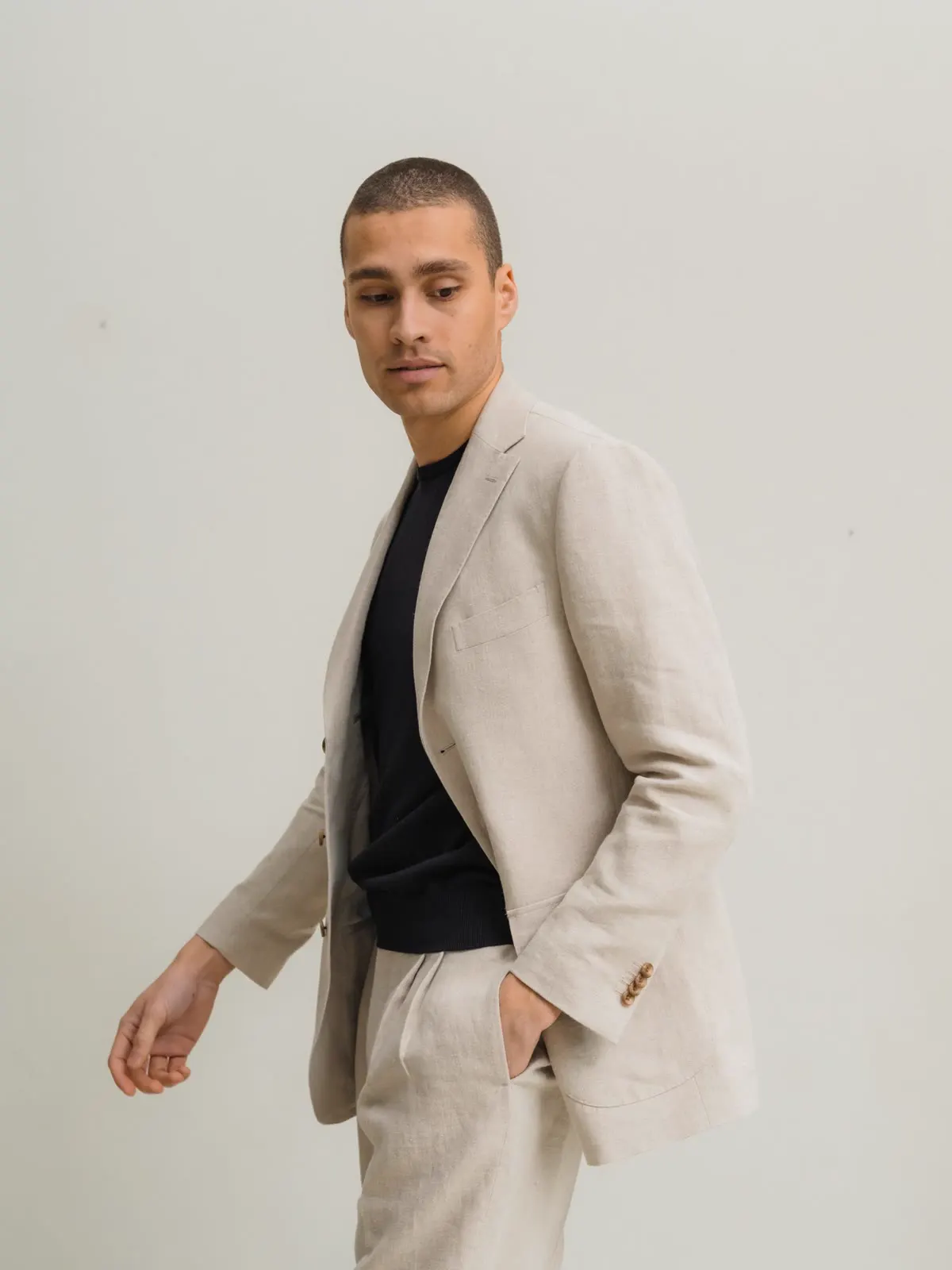 Man in a light linen suit and black T-shirt, in motion