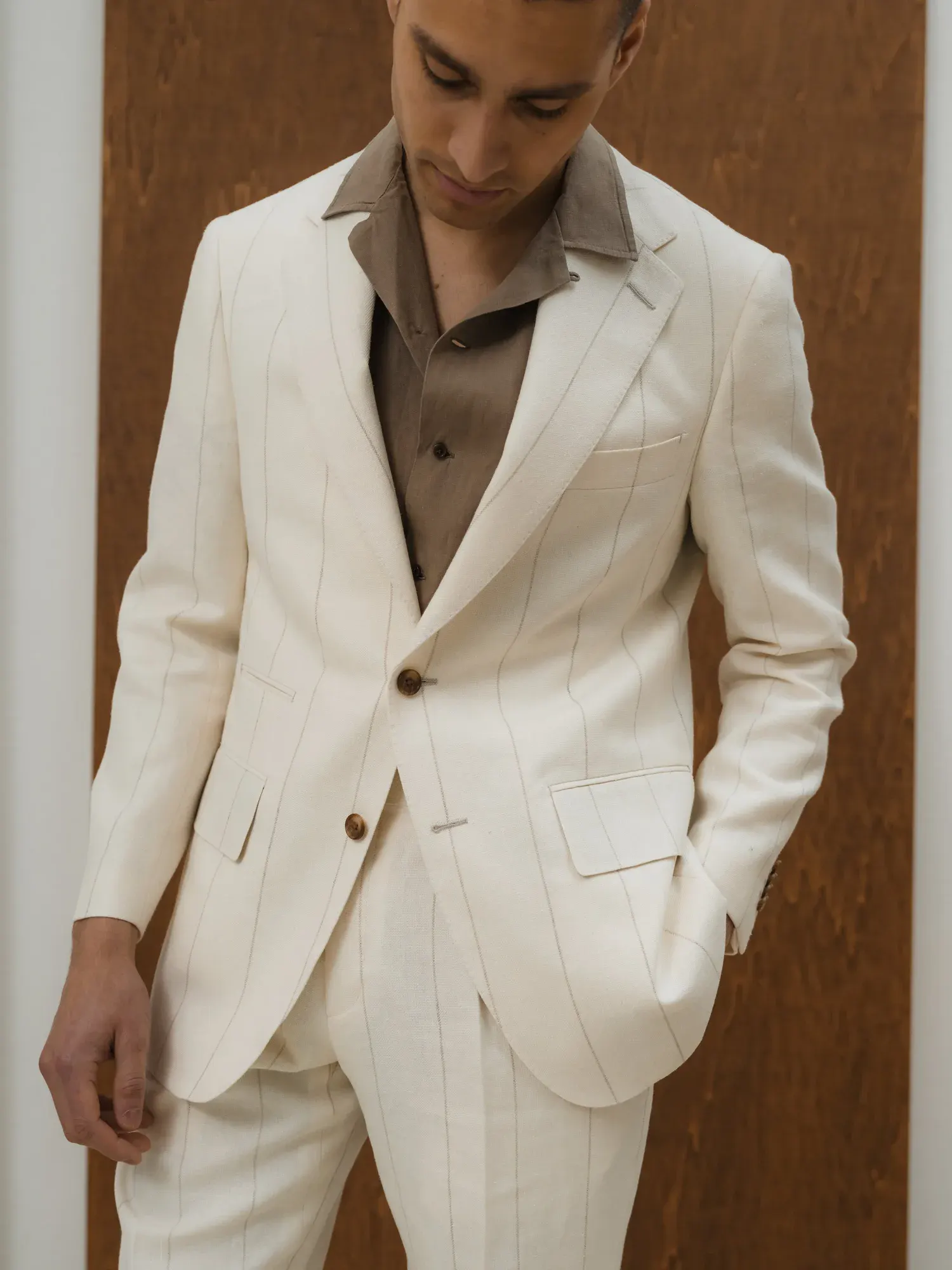 Close-up of an off-white linen suit with a brown shirt