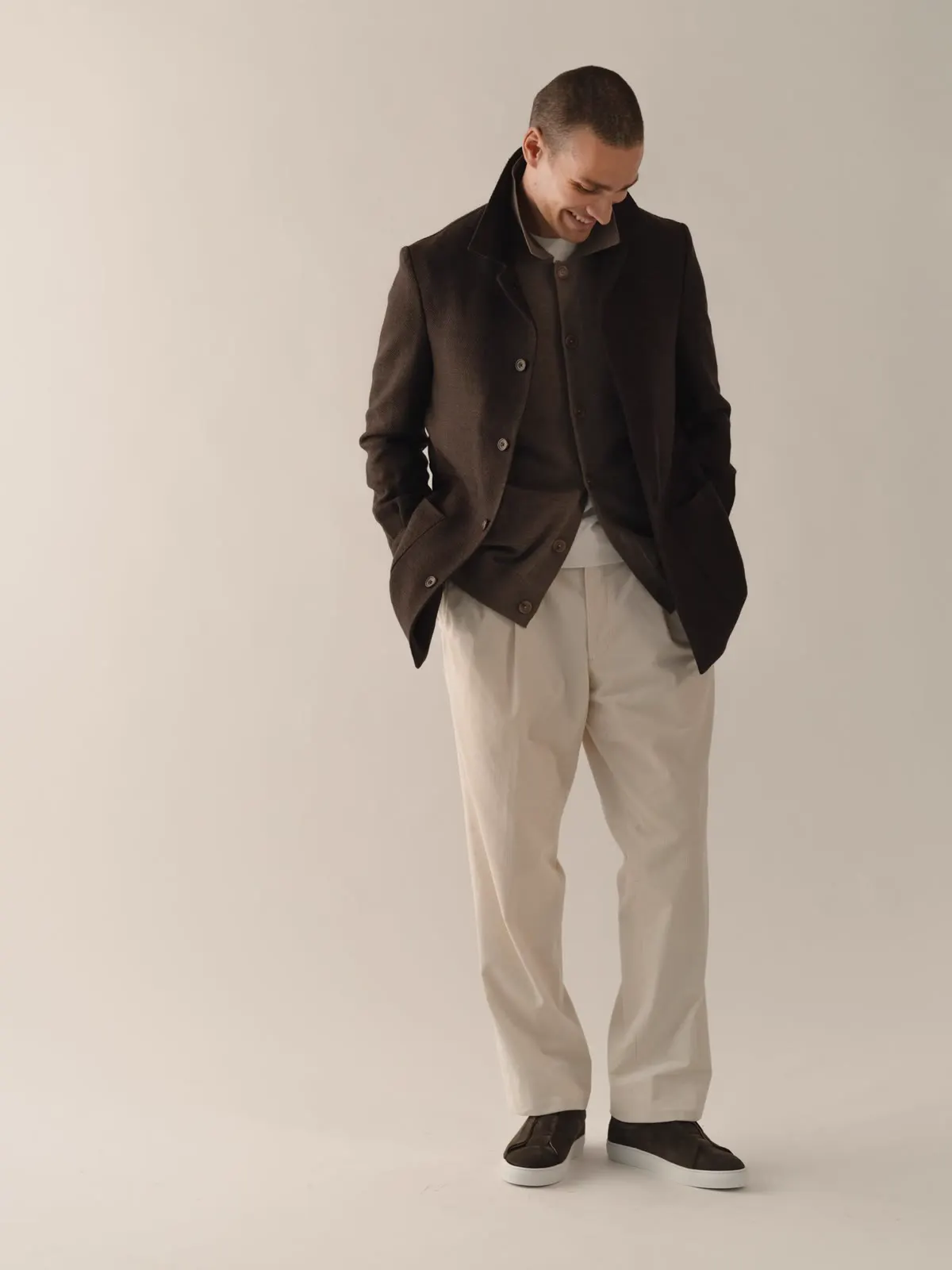Man in a dark brown hybrid jacket with his hands in his pockets