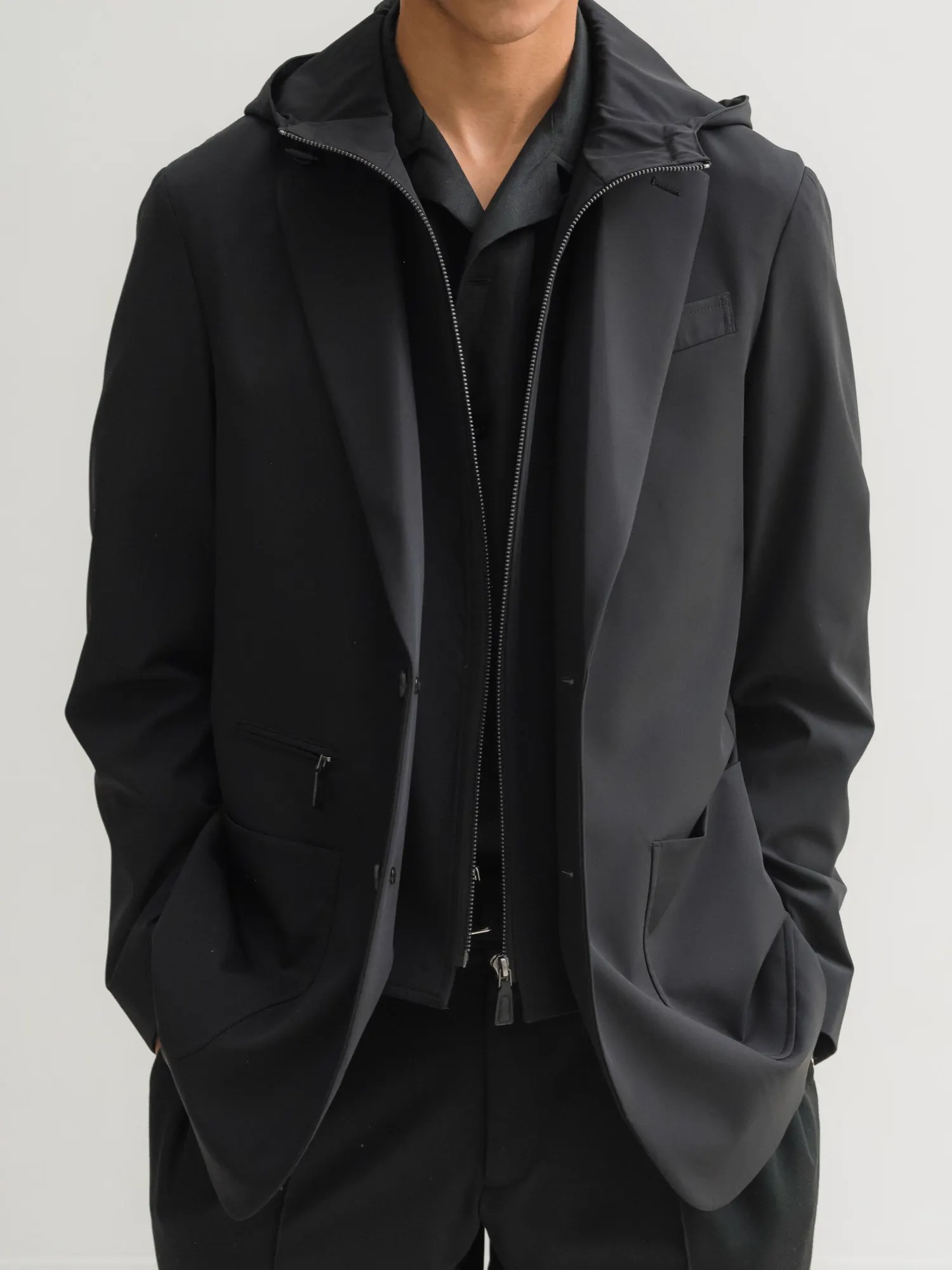 Man in a black jacket with an inner zip bib and hood