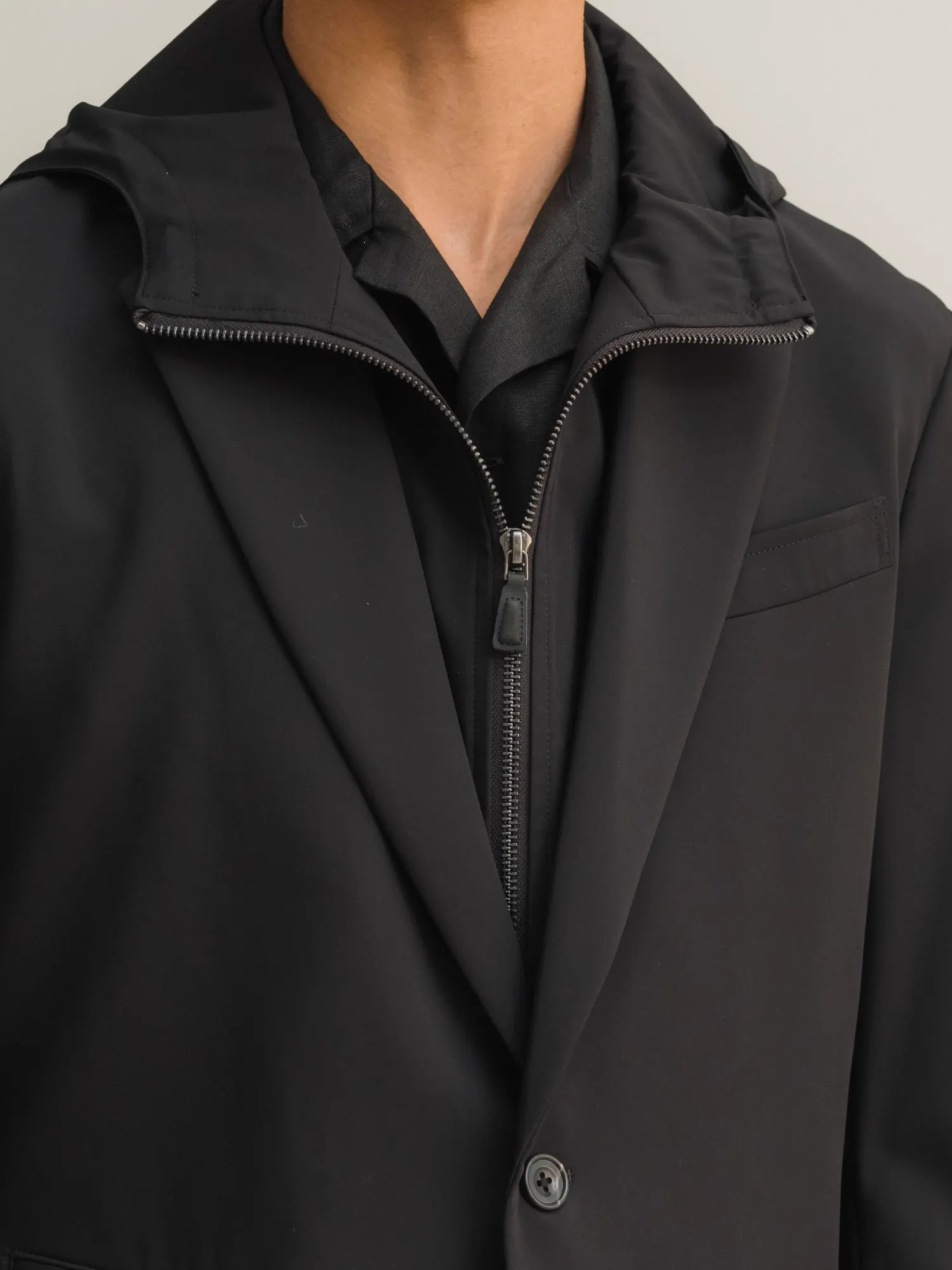 Close-up of a black jacket with lapels and an inner bib with a zip