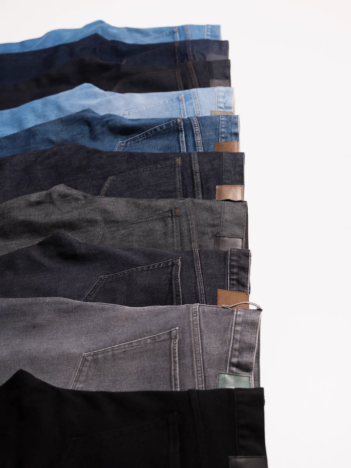 Stack of jeans in dark and light washes, seen from the side
