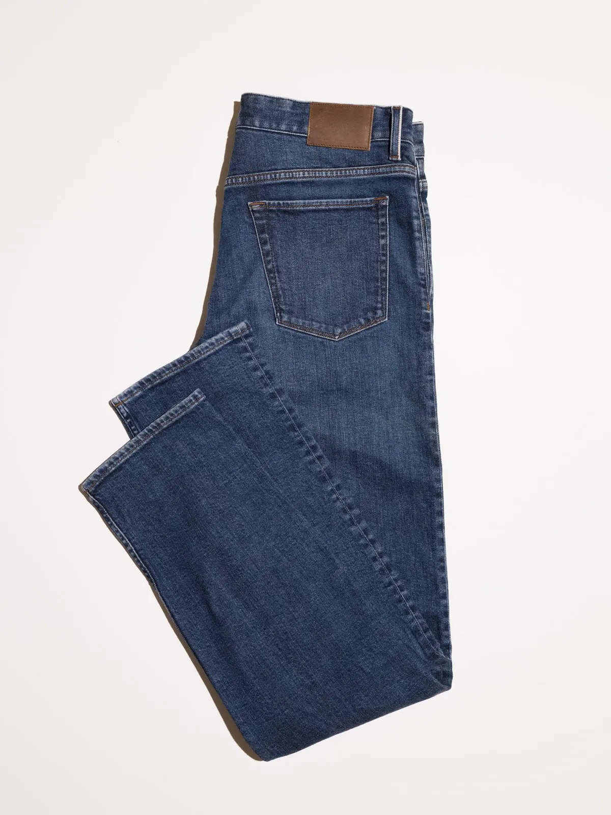 Dark blue jeans folded on a white background