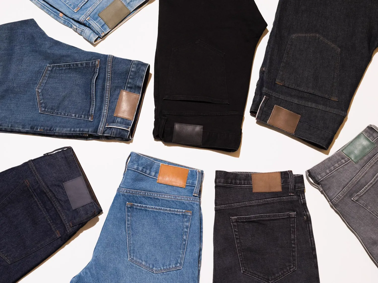 Jeans in different washes laid out in a circle, with leather back patches