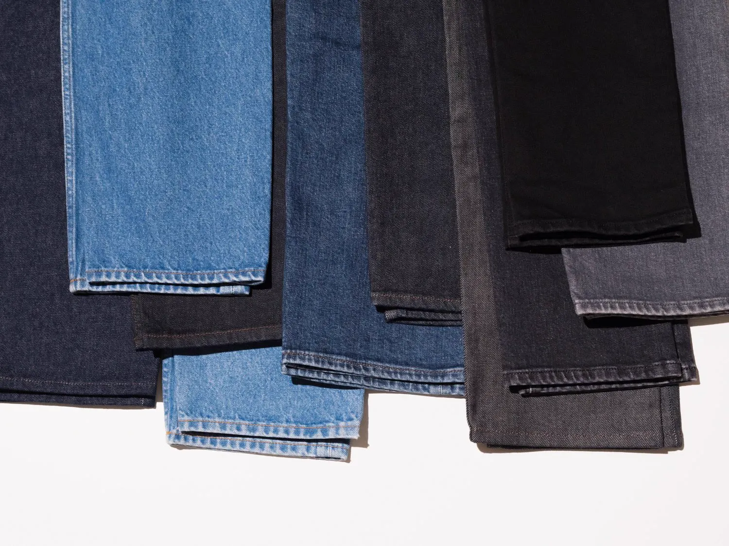Jeans i blå, sorte og grå vaske hængt op med oplæg