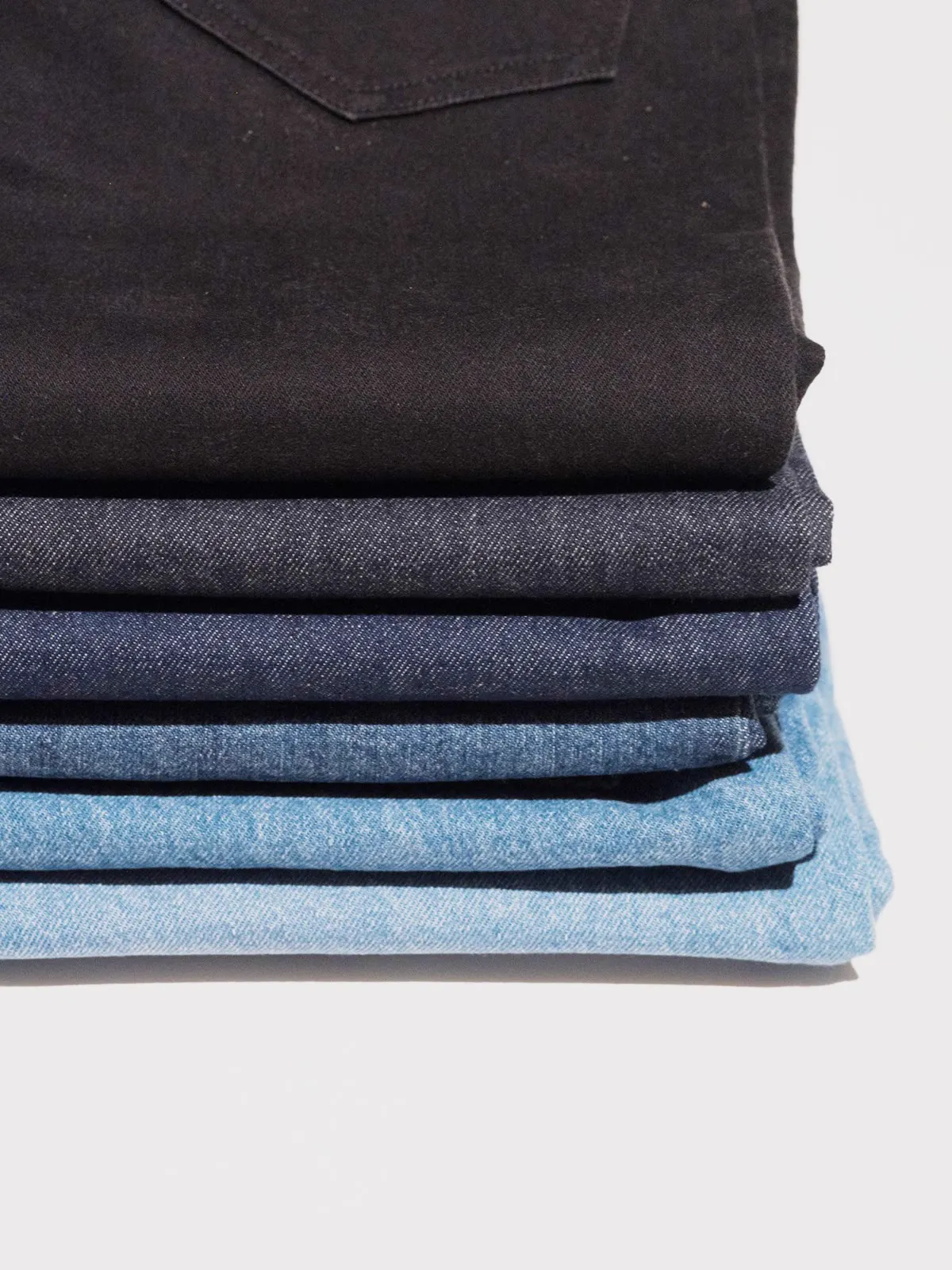 Stak af foldede jeans fra sort til lys blå