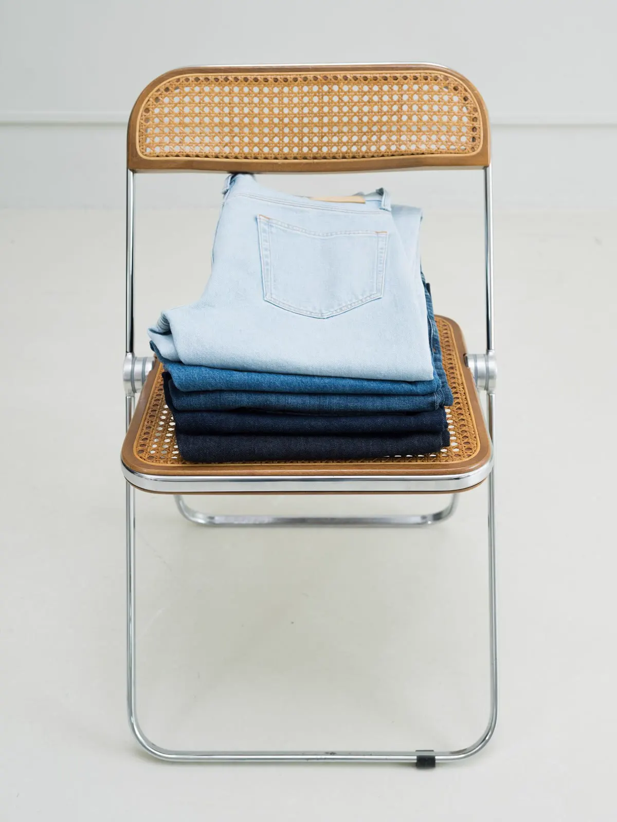 Stak af lyse og mørke jeans på en klapstol