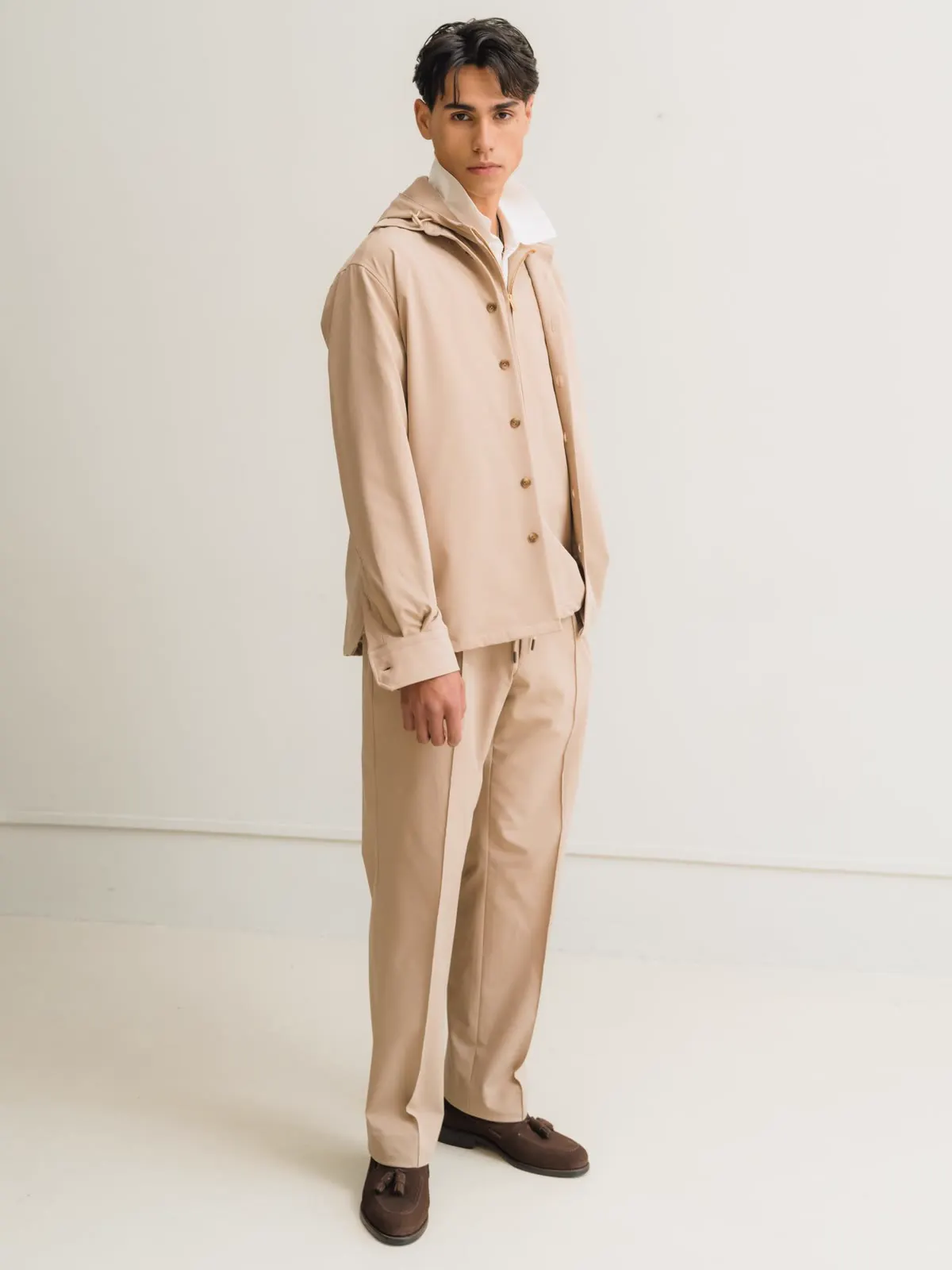 Man in a light brown overshirt and matching trousers, seen from the front