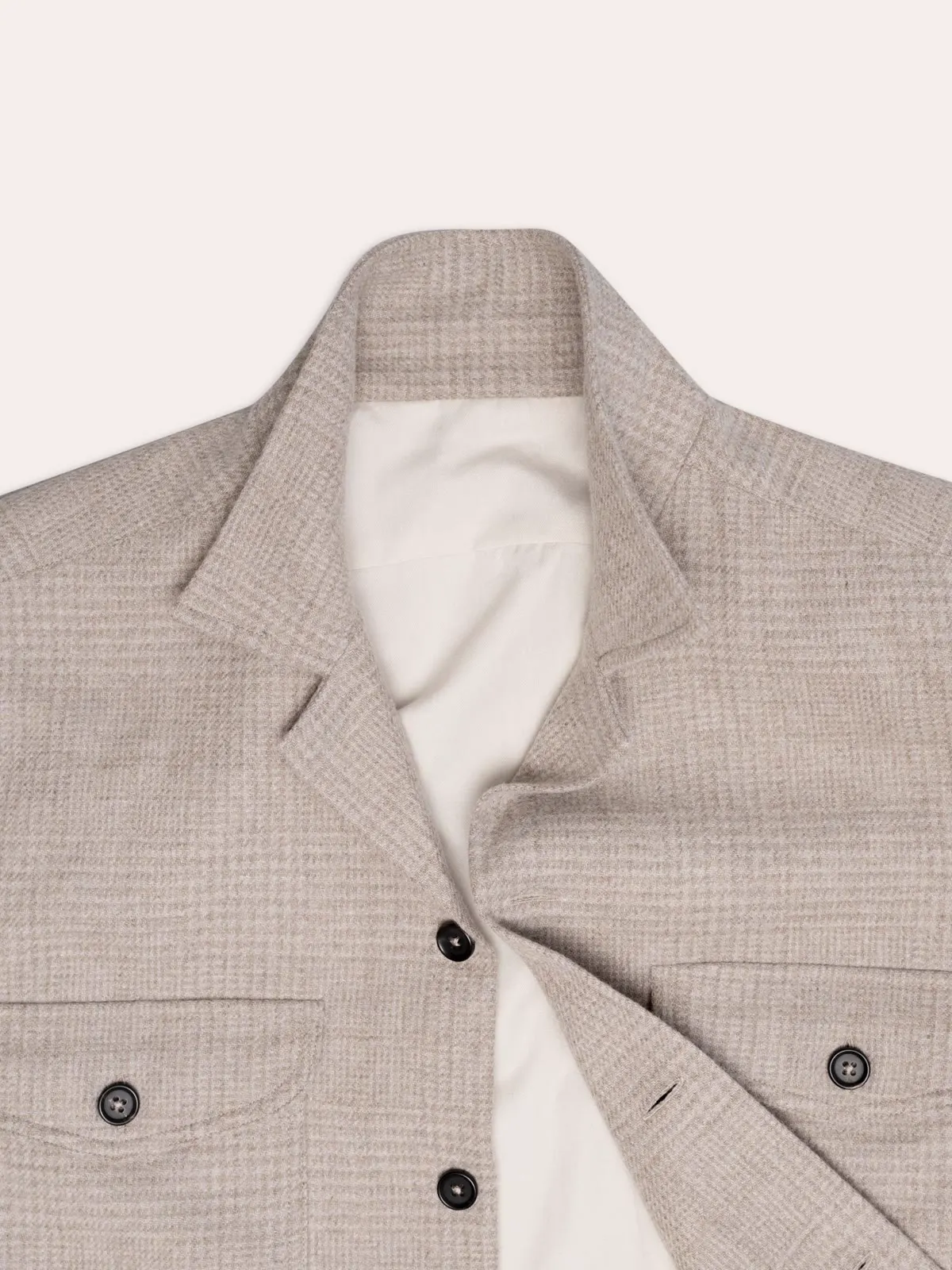 Close-up of a light checked shirt jacket with chest pockets and buttons