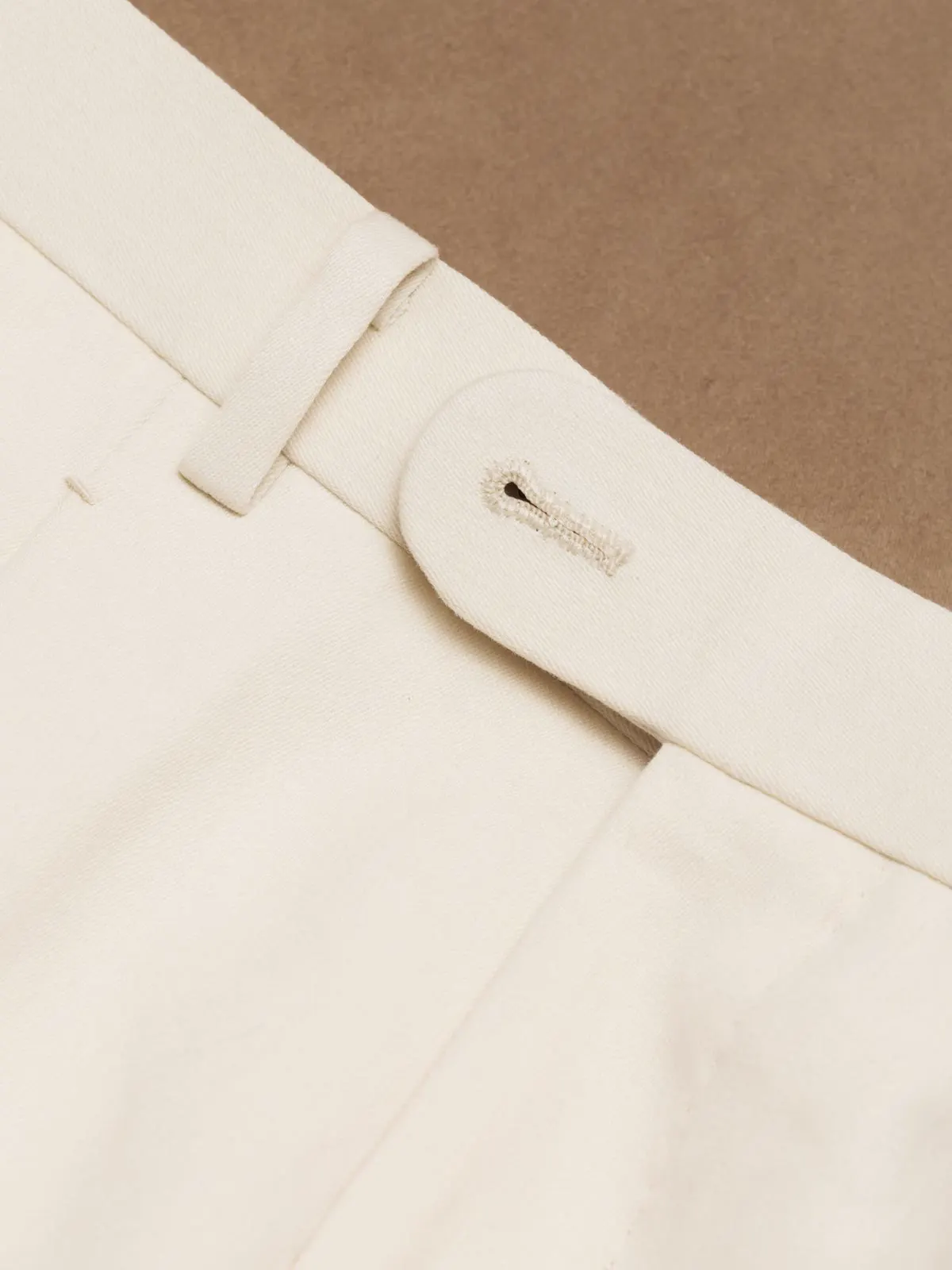Close-up of the waistband and belt loop on light trousers