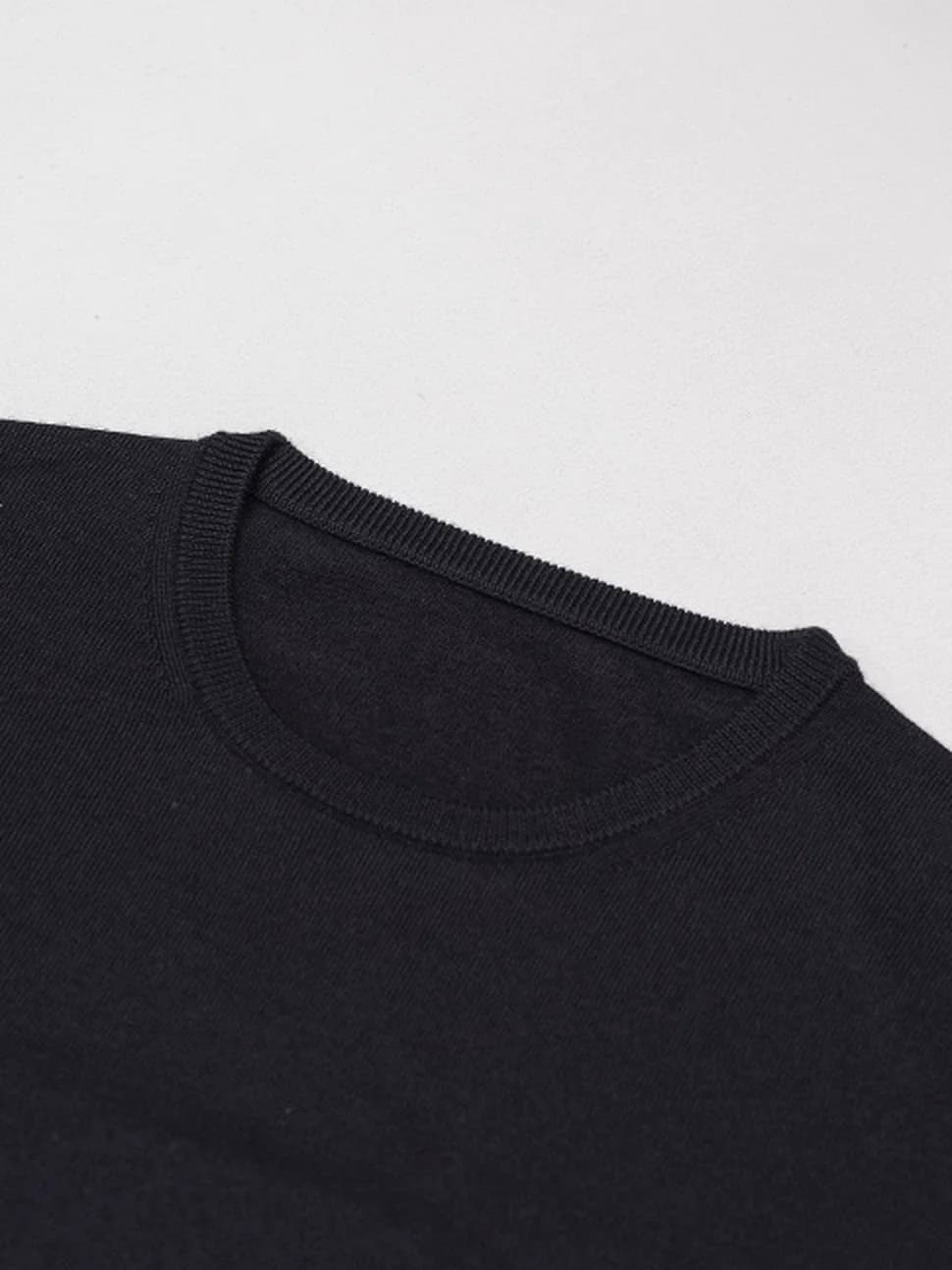 Halskant på mørk merino-crewneck, tæt på