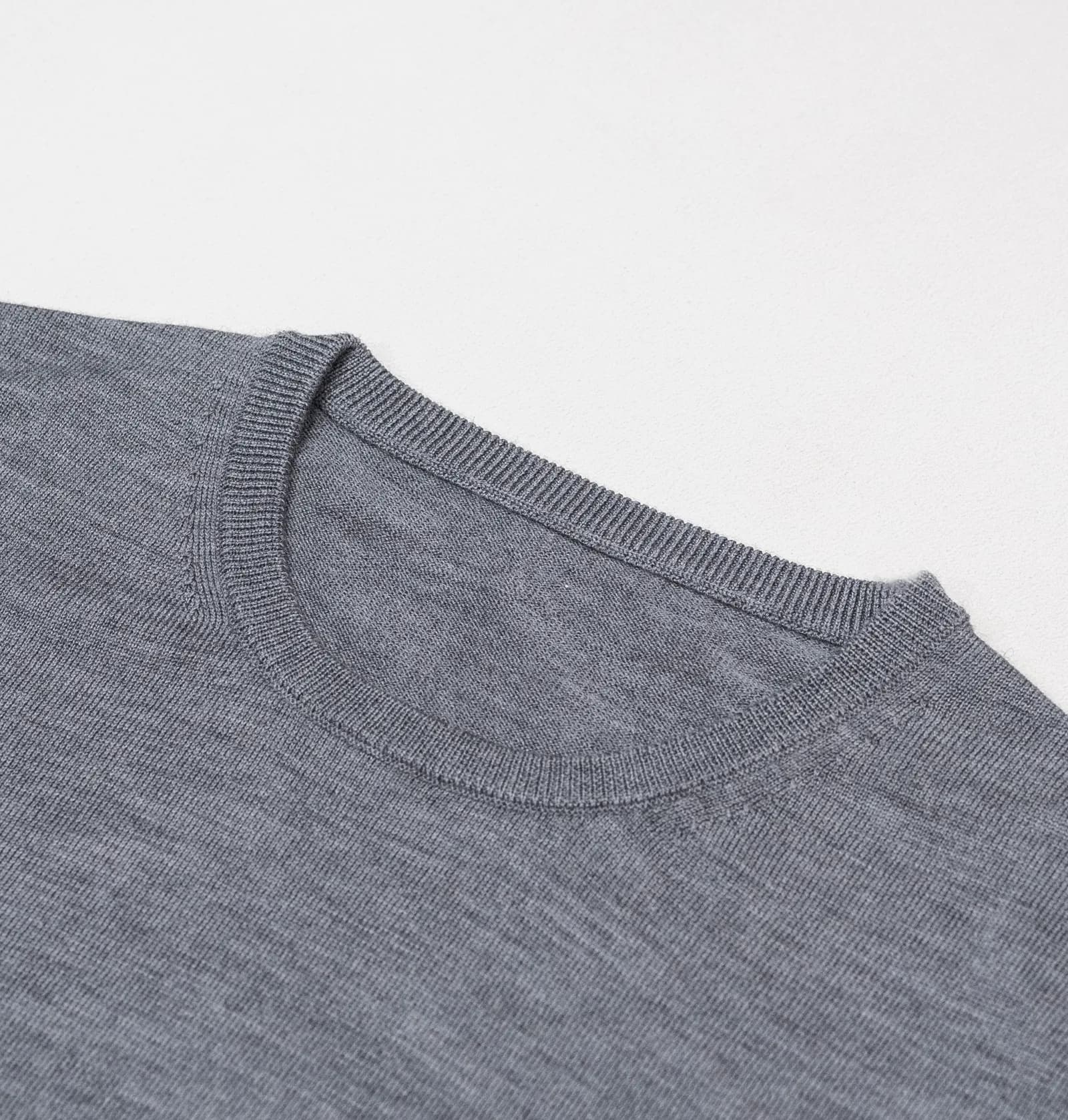 Ribkant ved halsen på grå merino-crewneck, tæt på