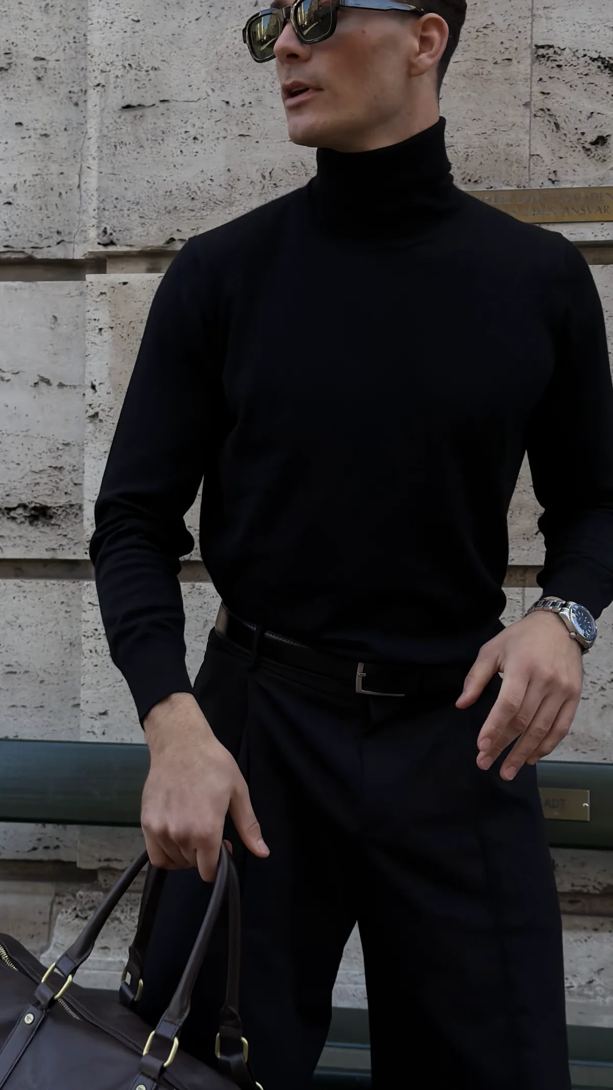 Sort merino-rullekrave i fuld figur med weekendtaske