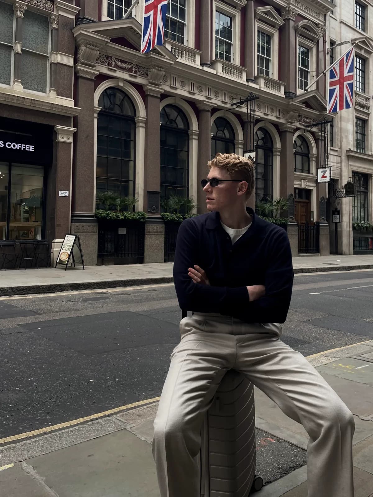 Navy merino V-neck over hvid tee, siddende på gaden i London