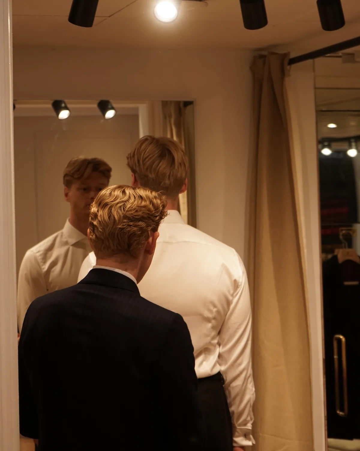 Gæst prøver tøjet foran spejlet i prøverummet i Showroomet
