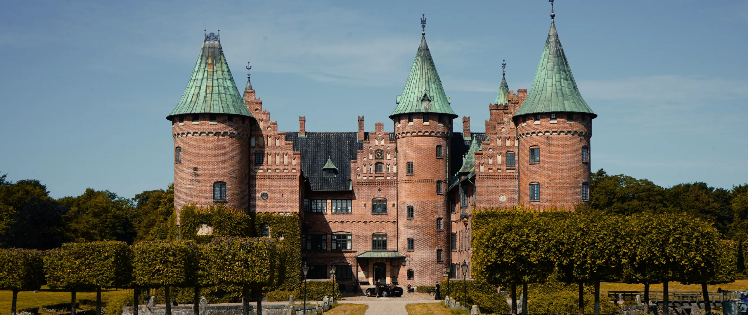 Slot med grønne tårnspir fra House of Vinterbergs AW26-kampagne