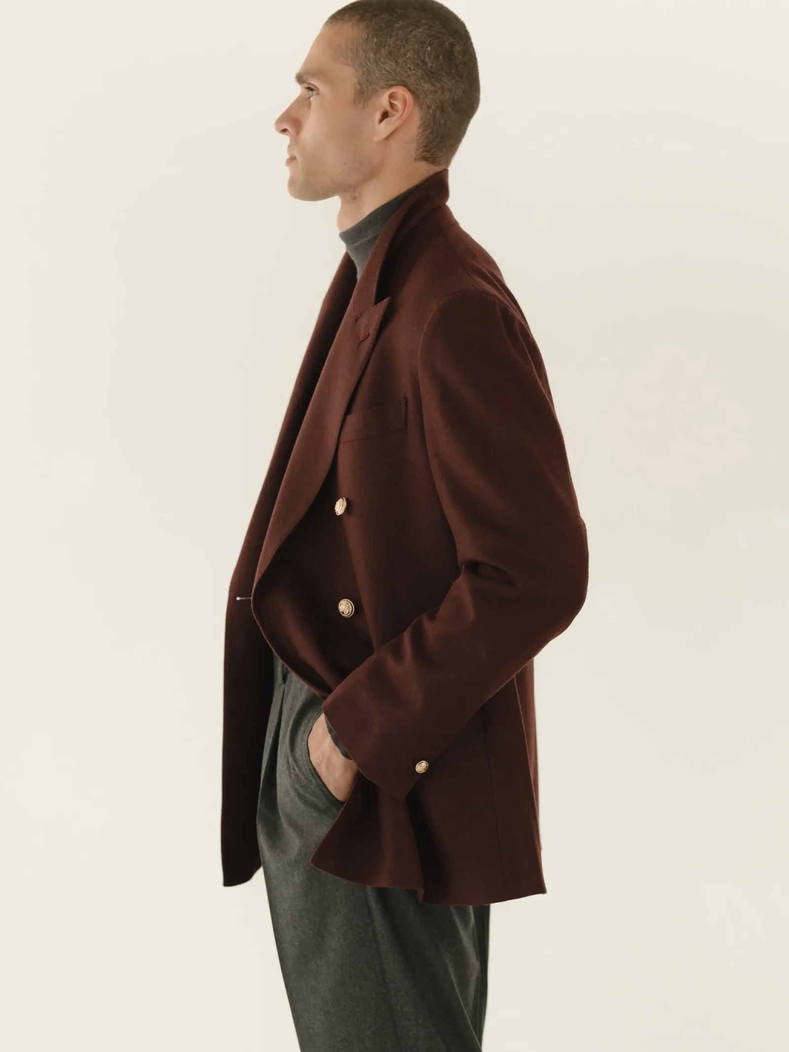 Burgundy double-breasted blazer worn as a single piece over dark trousers
