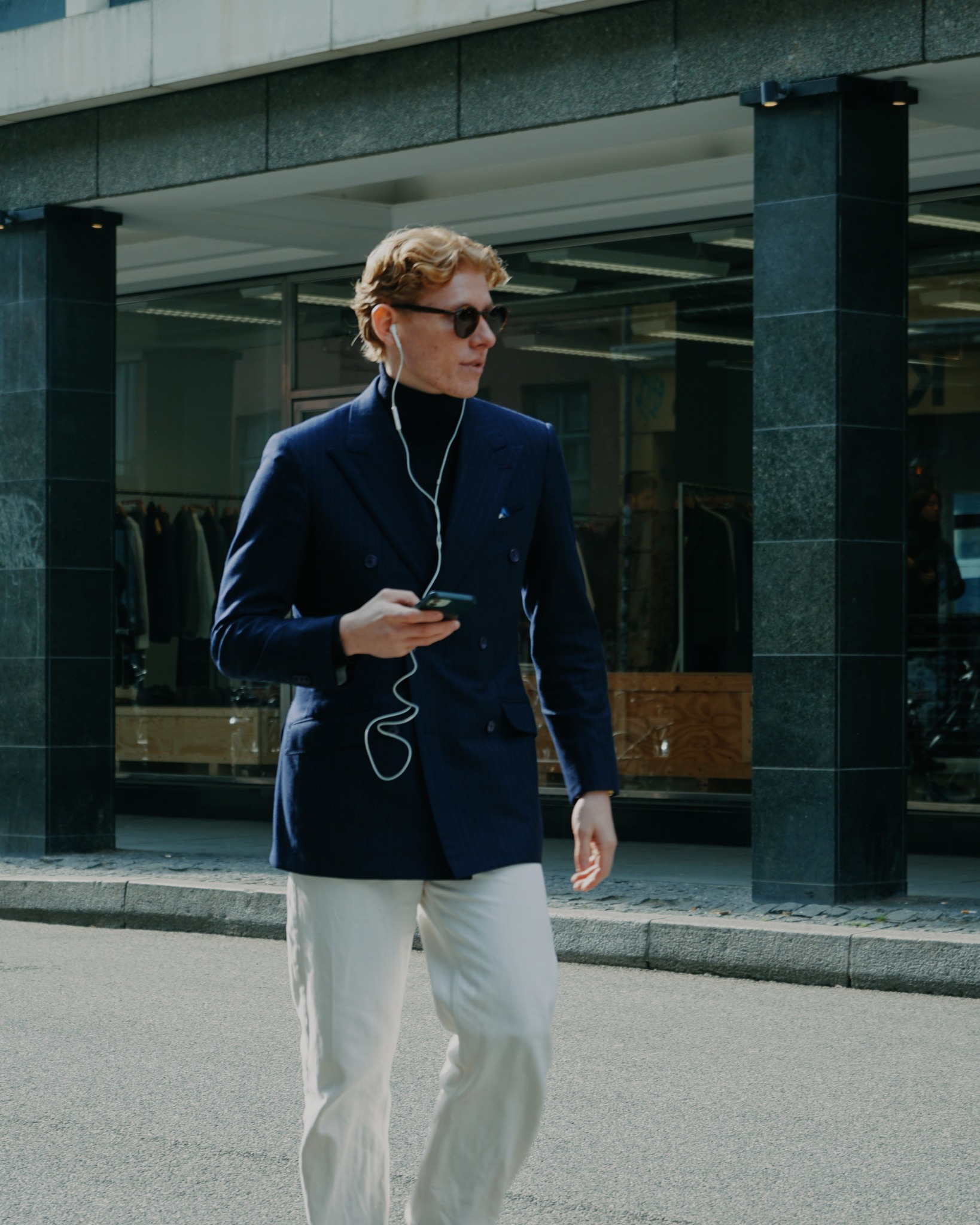 Navy double-breasted blazer over white trousers in Copenhagen
